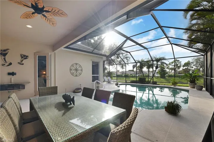View of pool with  enclosure, a patio area, and ceiling fan
