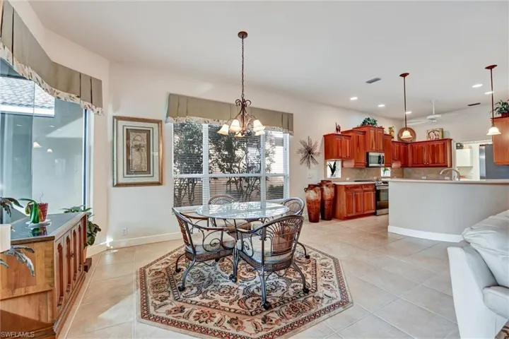 Dining room with a notable chandelier, light tile patterned flooring, plenty of natural light, and sink