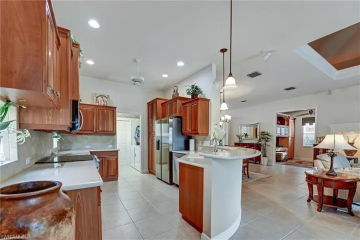 Kitchen with kitchen peninsula, pendant lighting, ceiling fan, and light tile patterned flooring