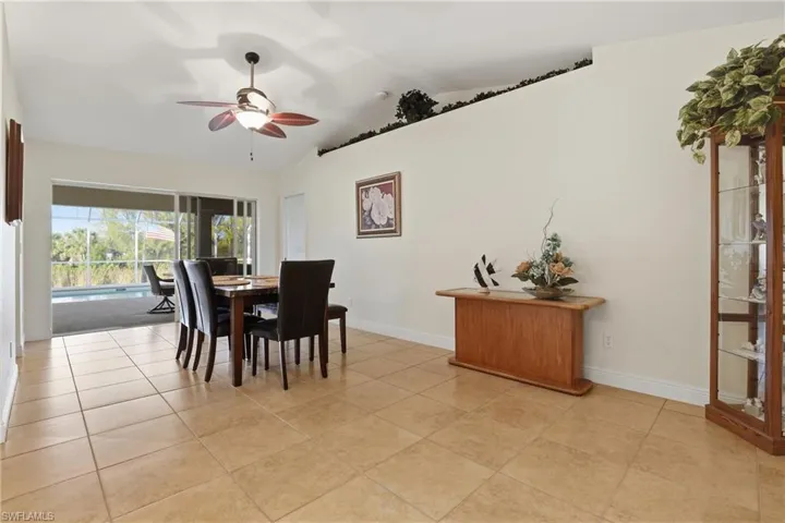 Dining space with ceiling fan, vaulted ceiling, and light tile patterned floors