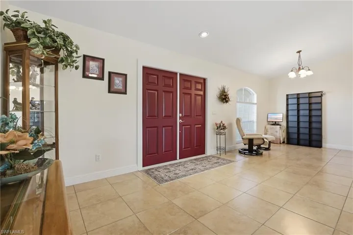 Foyer entrance with vaulted ceiling, light tile patterned floors, a chandelier, and recessed lighting
