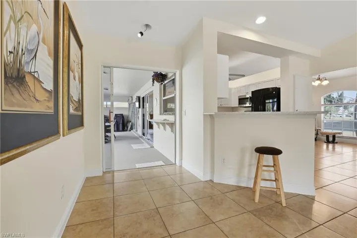 Hallway with a chandelier and light tile patterned floors