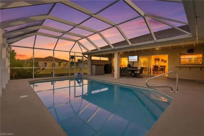 Outdoor pool featuring a sunroom, a lanai, a patio area, and outdoor dining space