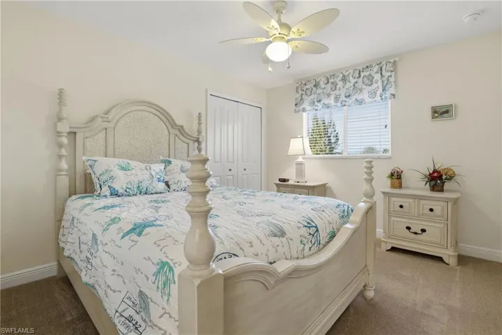 Carpeted bedroom featuring a closet and a ceiling fan