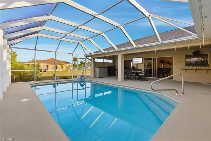 Outdoor pool with a sunroom, a lanai, a patio area, and outdoor dining space