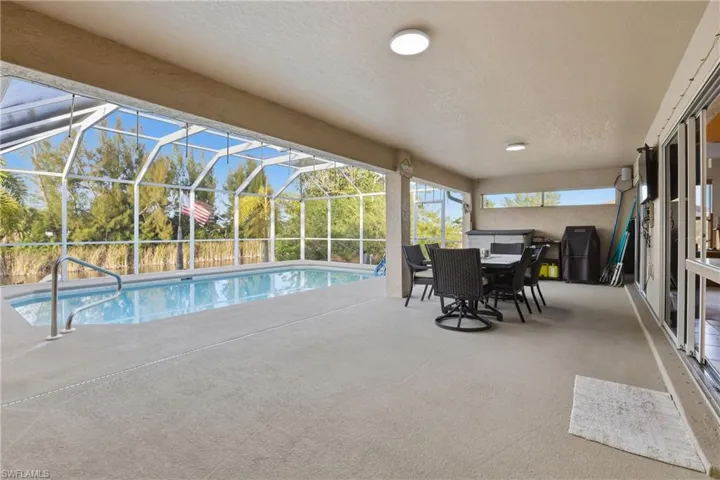 Outdoor pool featuring a patio area, a sunroom, and a lanai