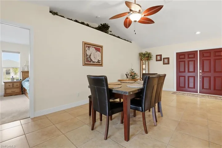 Dining area featuring light tile patterned floors, a ceiling fan, vaulted ceiling, and recessed lighting