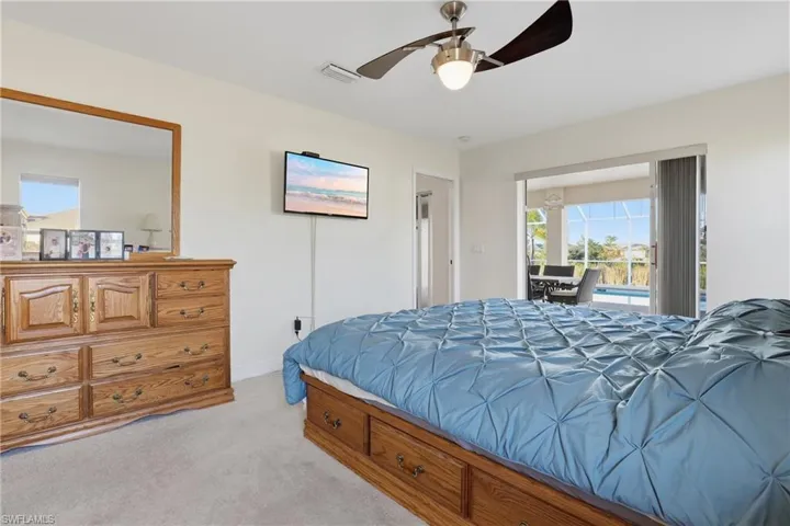 Bedroom with light carpet, access to outside, a sunroom, and a ceiling fan