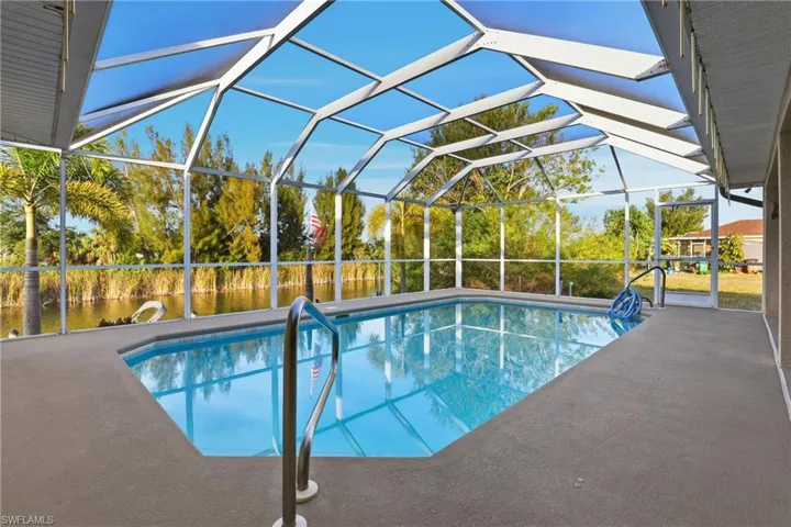Outdoor pool featuring a sunroom, a lanai, and a patio