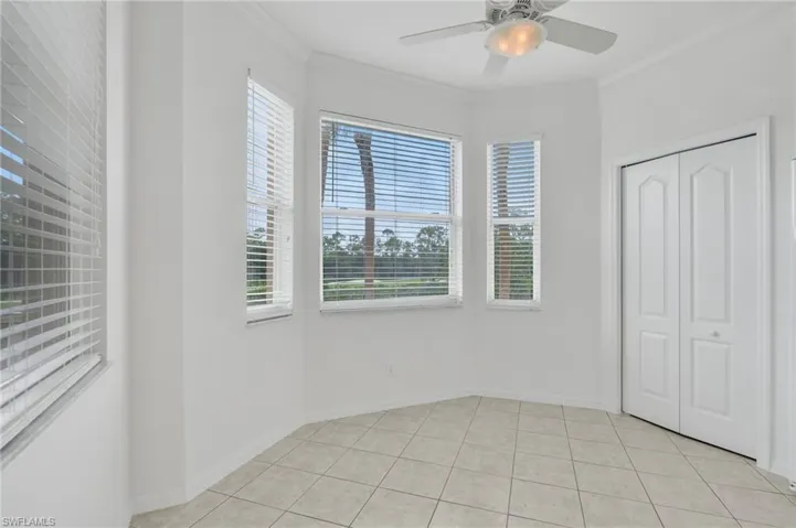 Breakfast area , multi-window bay area featuring tile flooring, neutral walls, ceiling fan with light fixture, and double-panel closet doors