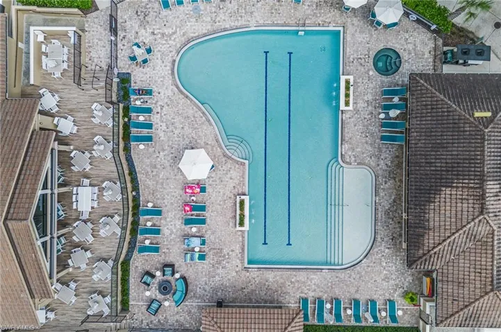 Community pool area featuring lap lanes, an integrated spa, tiled patio hardscaping, and built-in water features