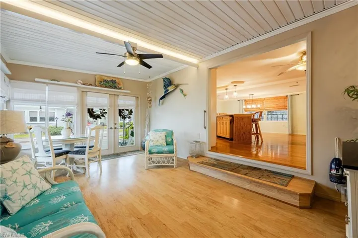Living room featuring wooden ceiling, french doors, light hardwood / wood-style floors, crown molding, and ceiling fan