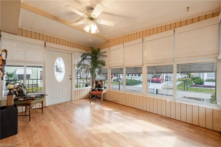 Unfurnished sunroom featuring ceiling fan, a wealth of natural light, and vaulted ceiling
