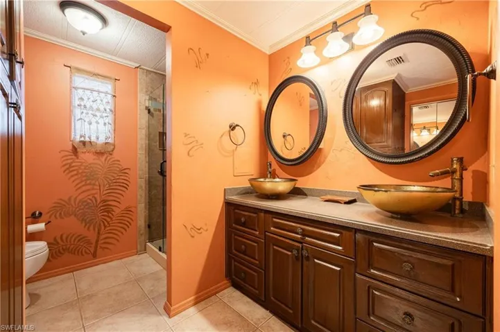 Bathroom featuring walk in shower, toilet, crown molding, and vanity