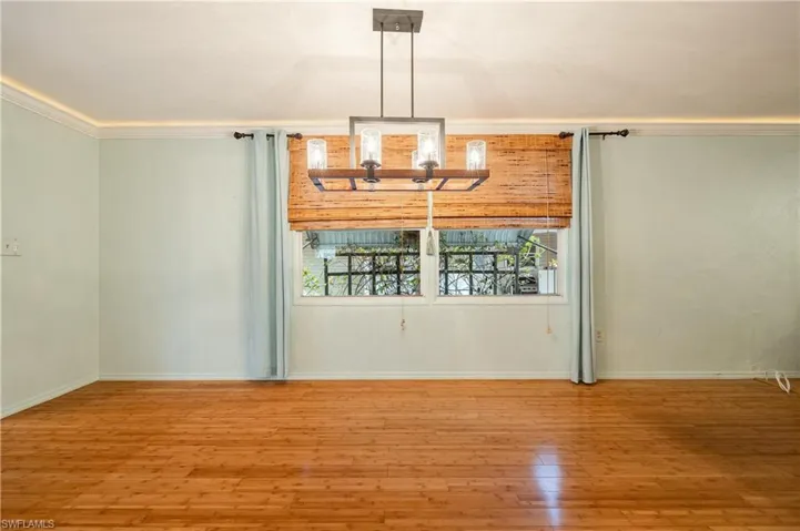 Unfurnished dining area with crown molding and hardwood / wood-style flooring