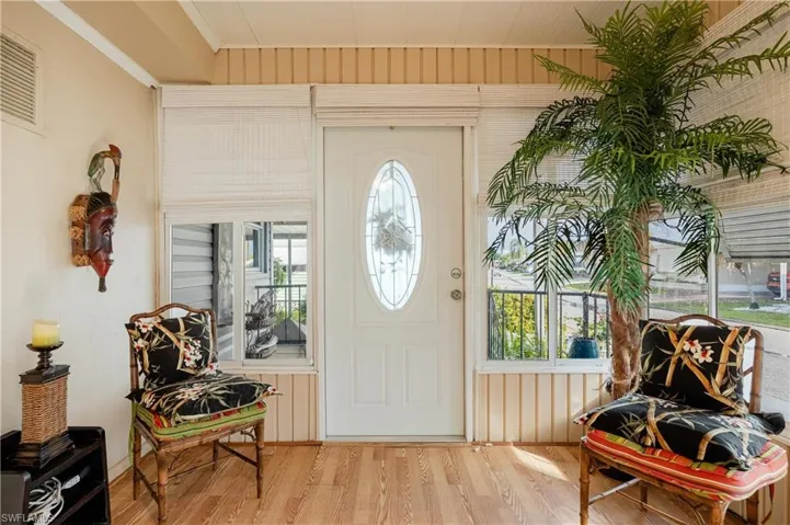 Foyer with plenty of natural light, wood walls, and light hardwood / wood-style flooring