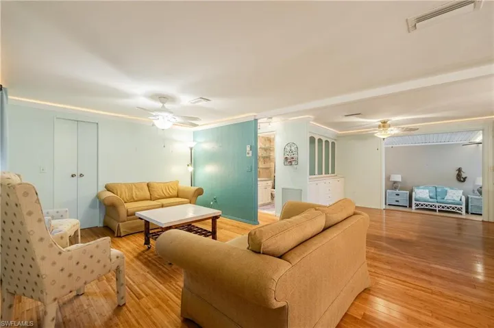 Living room featuring ornamental molding, ceiling fan, and light hardwood / wood-style floors