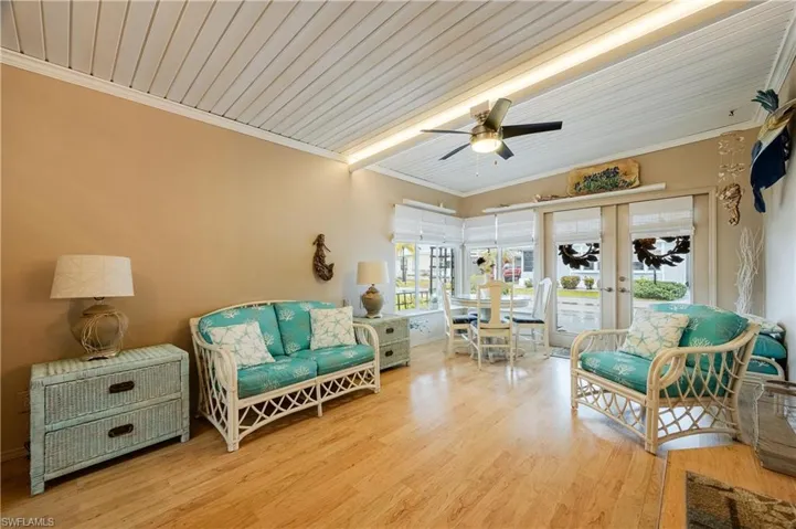 Living room featuring ornamental molding, light hardwood / wood-style flooring, ceiling fan, wood ceiling, and beam ceiling