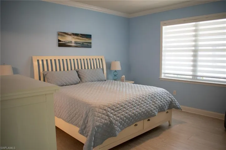 Bedroom featuring hardwood / wood-style flooring and crown molding