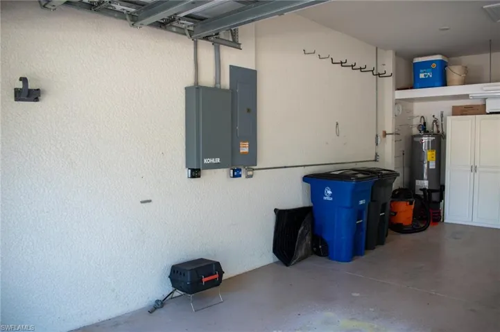 Garage featuring electric panel and electric water heater