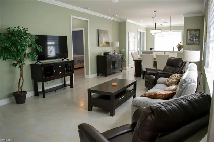 Tiled living room featuring crown molding