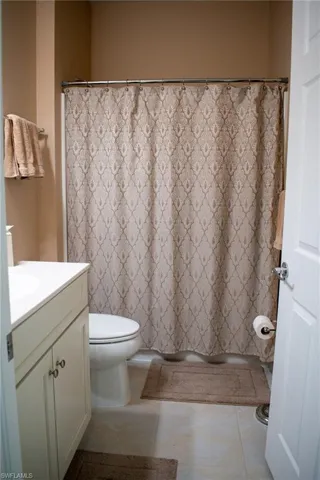 Bathroom featuring tile patterned flooring, vanity, and toilet