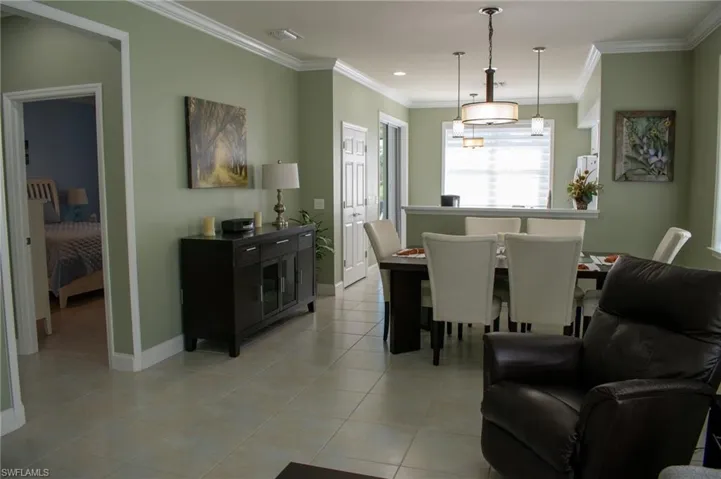 Dining room featuring light tile patterned floors and crown molding