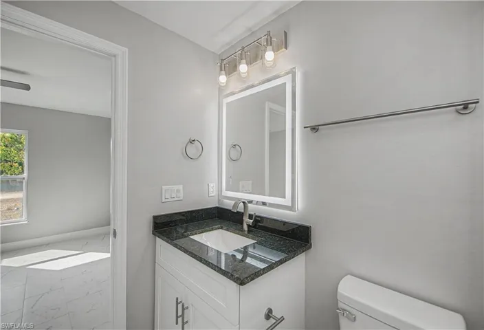 Bathroom with marble finish flooring and vanity