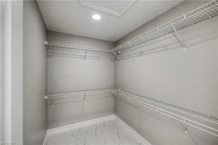 Walk in closet with light marble finish floors