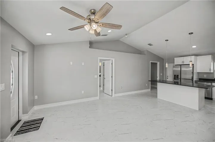 Kitchen featuring recessed lighting, appliances with stainless steel finishes, white cabinetry, light marble finish floors, and open floor plan