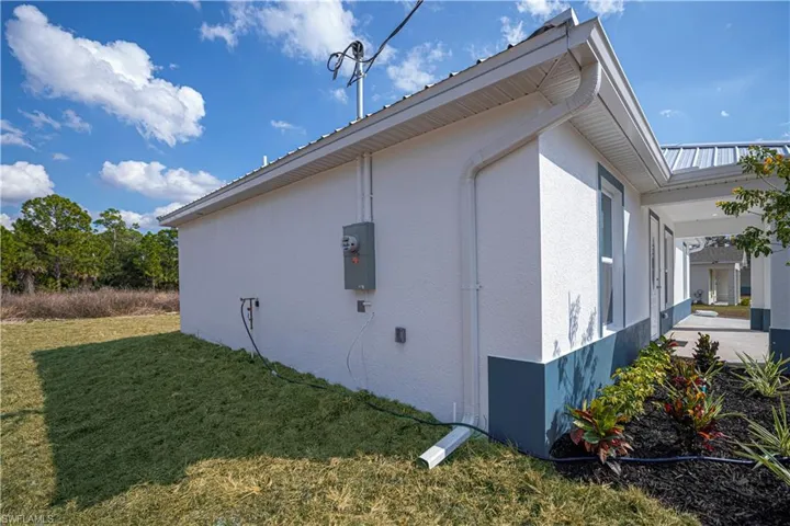 View of property exterior featuring a lawn and stucco siding