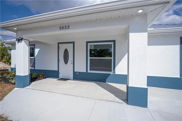 Entrance to property with covered porch and stucco siding