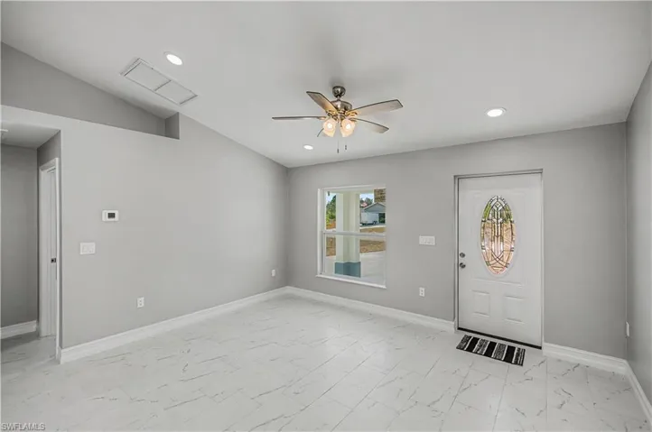 Entrance foyer with light marble finish floors, ceiling fan, lofted ceiling, and recessed lighting