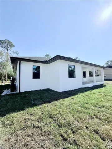 View of side of property with a yard and a patio