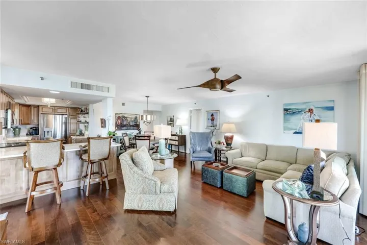 Living room featuring ceiling fan and dark wood-style floors