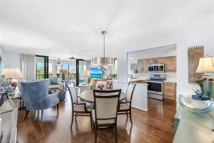 Dining area featuring dark wood-type flooring, floor to ceiling windows, and ceiling fan