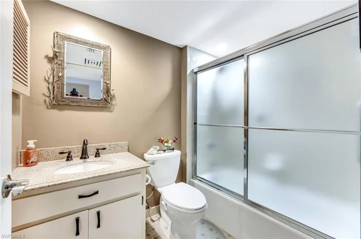 Bathroom with vanity and enclosed tub / shower combo