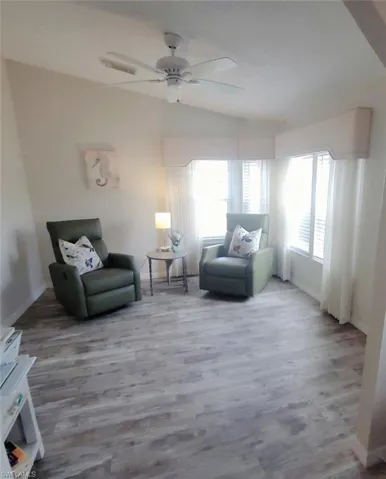 Rearranged den featuring lofted ceiling, wood finished floors, and ceiling fan