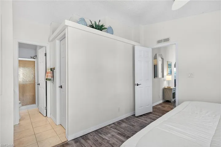 Bedroom featuring wood finished floors, a textured ceiling, ceiling fan, and a closet
