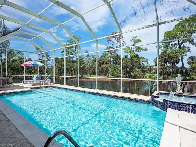 View of swimming pool with a water view, pool water feature, a lanai, an in ground hot tub, and a patio area