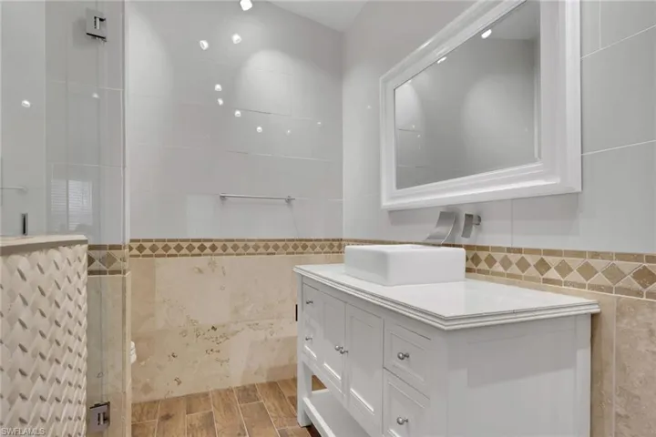 Contemporary bathroom featuring a white vanity with a rectangular vessel sink and wall-mounted faucet