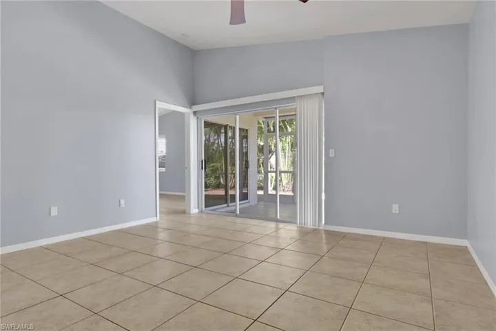 Spacious room featuring neutral tile flooring and light blue walls