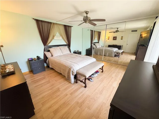 Bedroom with ceiling fan, a closet, and light hardwood / wood-style flooring