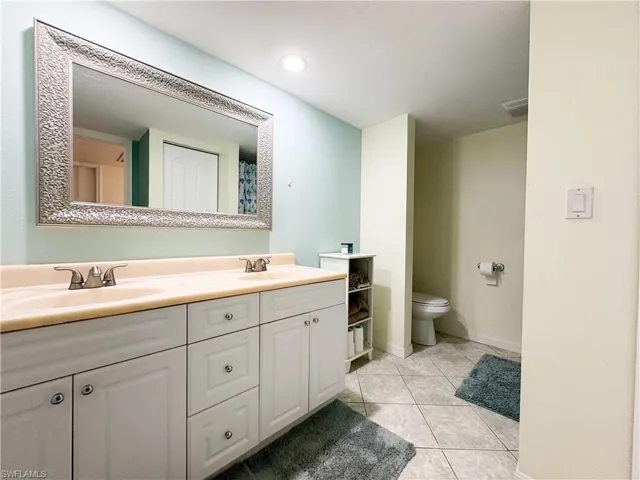 Bathroom featuring vanity, tile patterned floors, and toilet