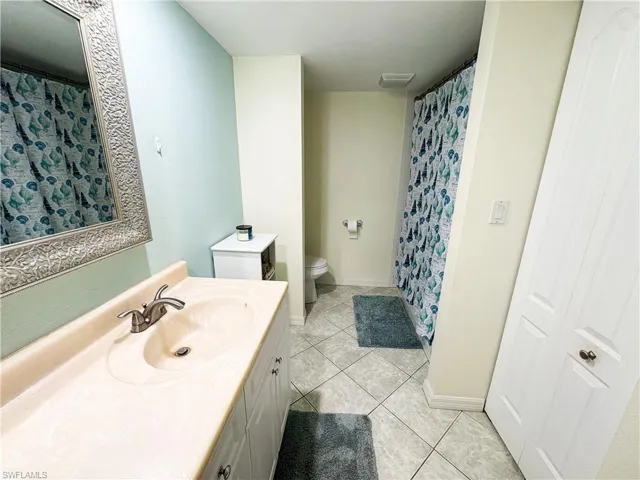 Bathroom featuring tile patterned floors, toilet, and vanity