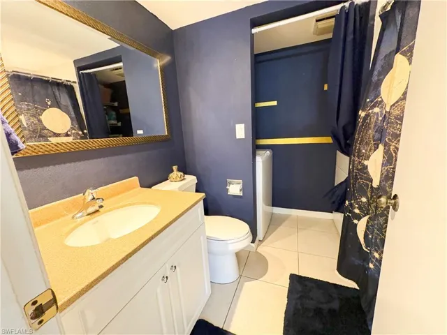 Bathroom featuring tile patterned flooring, vanity, and toilet