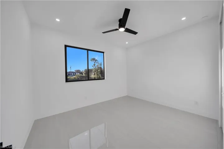 Interior space featuring large-format tile flooring, recessed lighting, and a modern black ceiling fan with an integrated light fixture