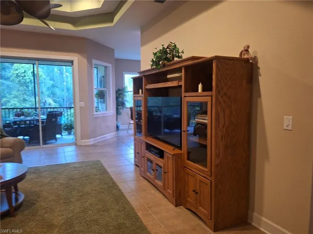 Living area featuring a ceiling fan and light tile patterned floors