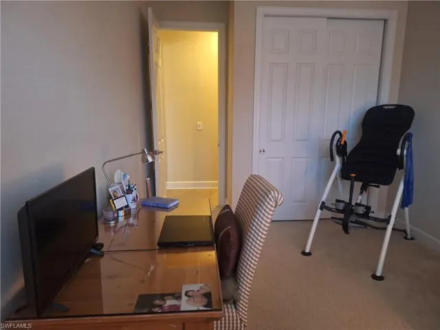 Carpeted office space with baseboards
