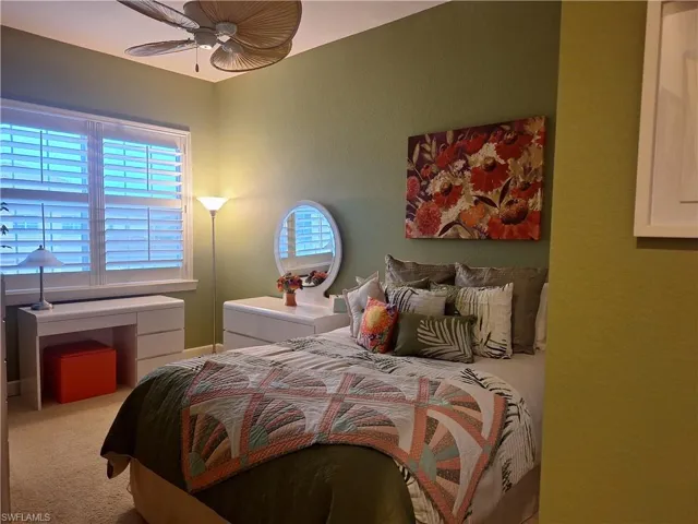Bedroom featuring multiple windows, carpet, and a ceiling fan